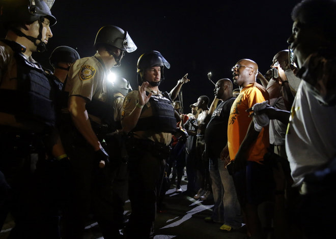 Officers and protesters face off along West Florissant Avenue Monday Aug. 10 2015 in Ferguson Mo. Ferguson was a community on edge again Monday a day after a protest marking the anniversary of Michael Brown's death was punctuated with gunshots. (AP