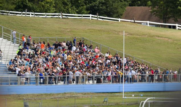 Students wait on the football field bleachers at Philip Barbour High School in Philippi