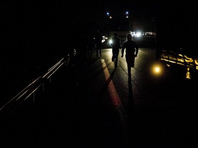 Migrants try to jump in a truck to pass through Channel Tunnel