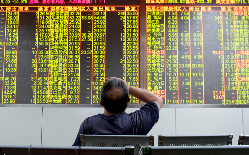 An investor agonizes over the falling market at a brokerage office in Jinhua city Zhejiang province Aug 24 2015. The Shanghai Composite Index plunged by 8.5 percent on Aug 24 the biggest one-day percentage loss since 2007. Green figures indicate stock