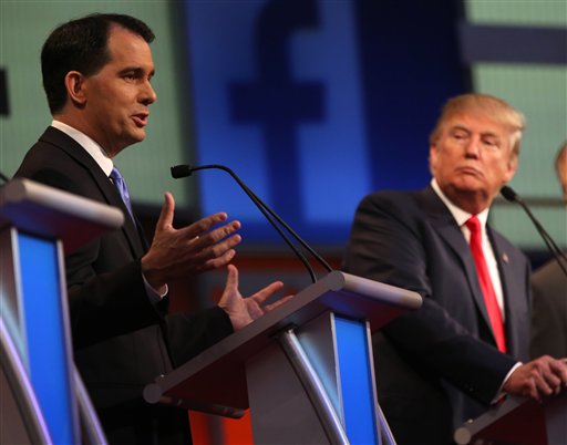 Republican presidential candidate Scott Walker speaks as Donald Trump listens during the first Republican presidential debate at the Quicken Loans Arena Thursday Aug. 6 2015 in Cleveland