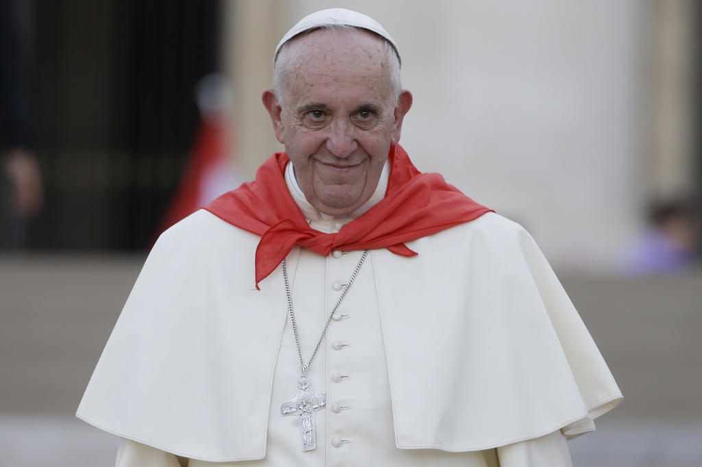 Pope Francis wears a red scarf as he leaves St. Peter's Square at the Vatican after an audience with Altar boys and girls Tuesday Aug. 4 2015