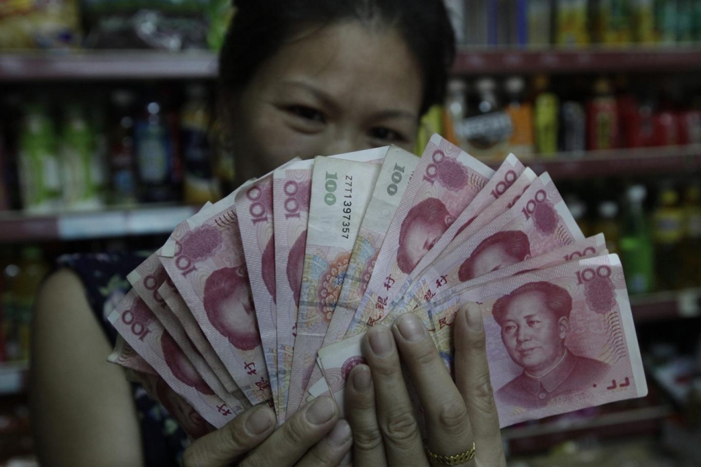 Chinese convenience store vendor shows her earnings in 100 Chinese Yuan