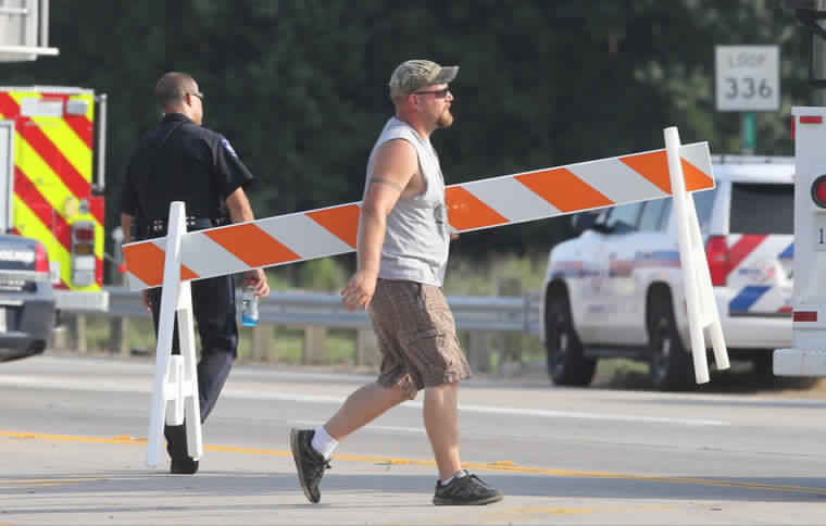 Officials gather near the scene of a series of explosions from the oil field chemical supply firm Drill Chem in Conroe Texas Friday Aug. 14 2015