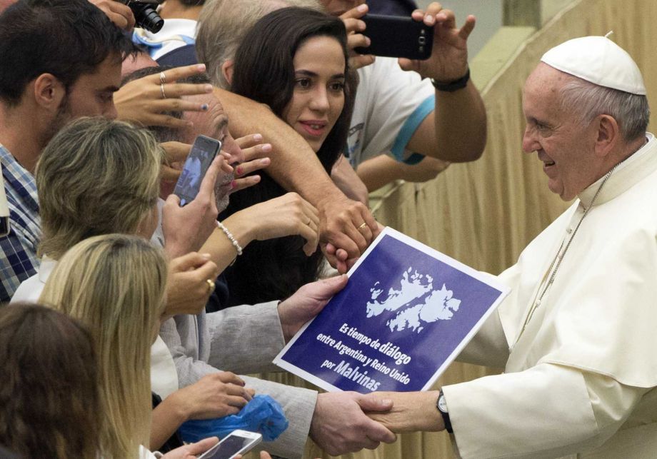 A placard which reads'It's time for dialogue between Argentina and the United Kingdom for Falklands, is held by faithful as Pope Francis is greeted during the weekly general audience in the Paul VI hall at the Vatican