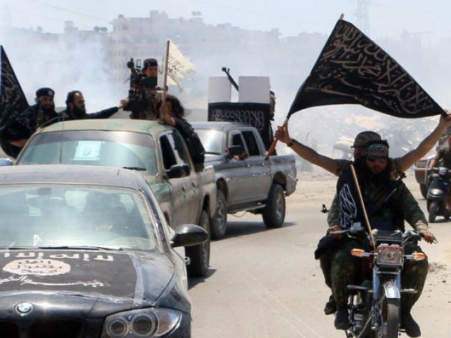 Fighters from al Qaeda's Syrian affiliate Al Nusra Front drive in the Syrian city of Aleppo flying flags