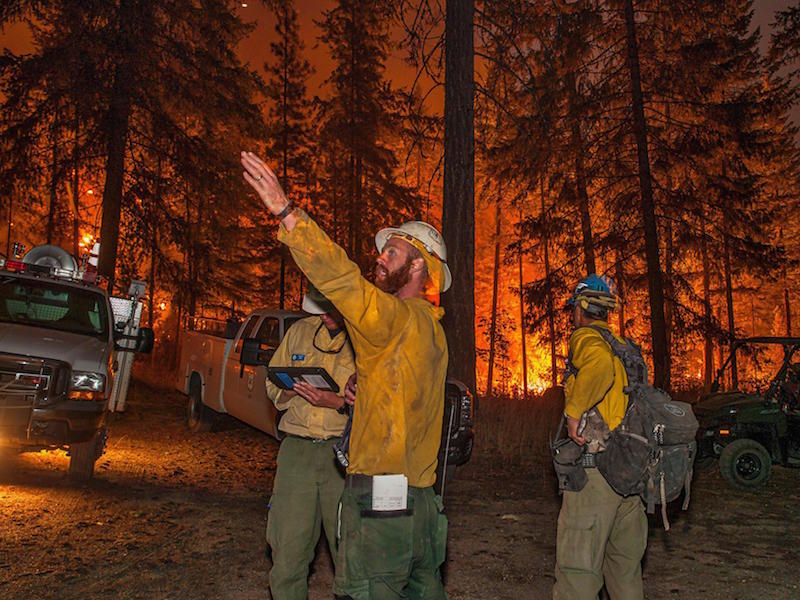 Firefighters battle the First Creek Fire northwest of Chelan Washington on the South Shore of Lake Chelan