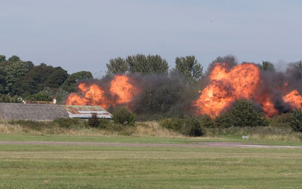 Flames erupt from the site of the fatal crash