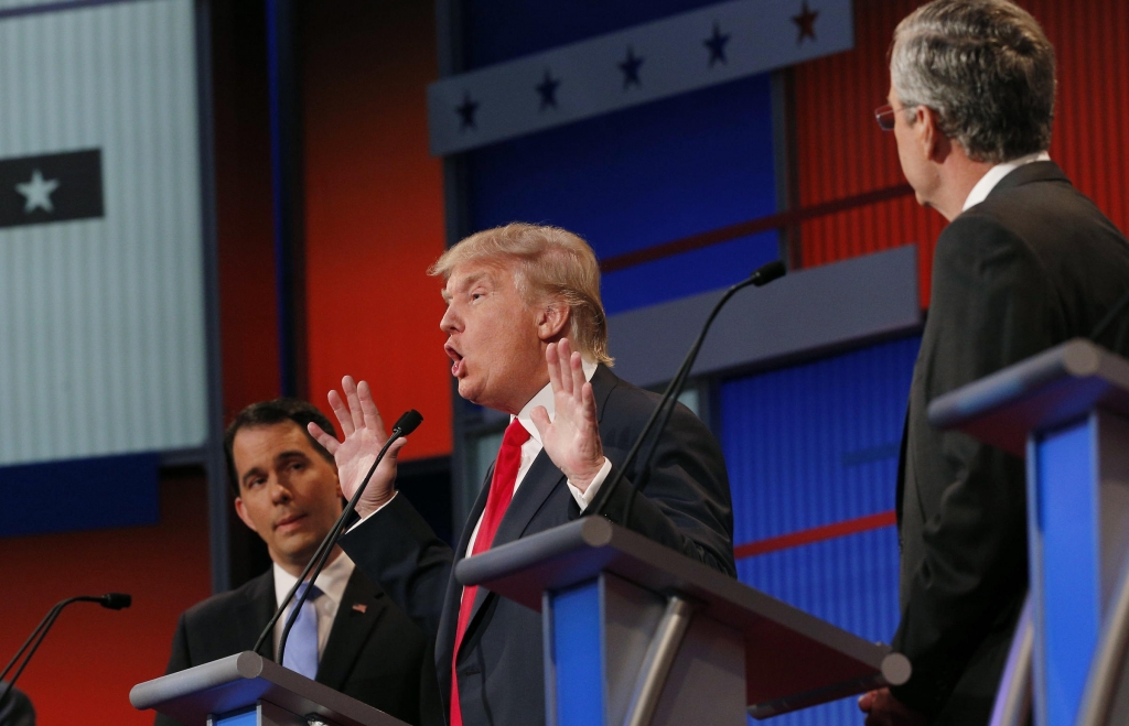 Donald Trump center stage as fellow candidates Scott Walker and Jeb Bush listen at the first official debate in Cleveland Ohio