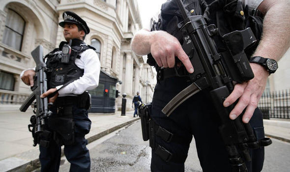 Police patrol the street with guns