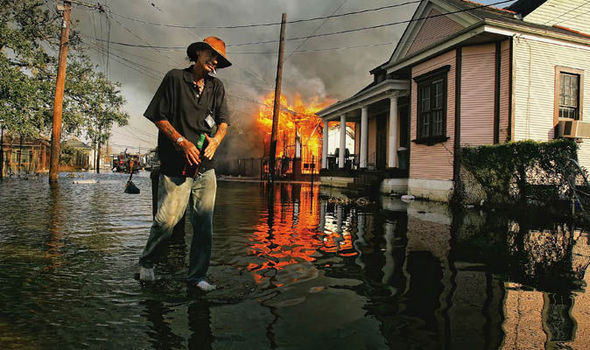 Robert Fontaine walks past a burning house fire in the 7th ward