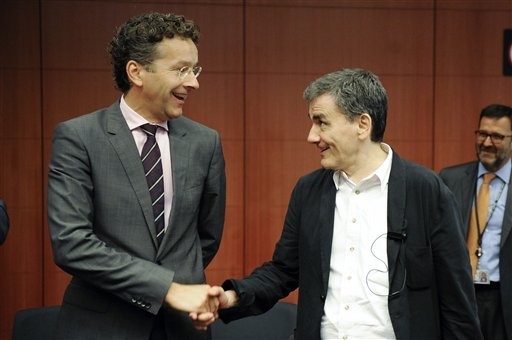 Dutch Finance Minister and chairman of the eurogroup Jeroen Dijsselbloem left shakes hands with Greek Finance Minister Euclid Tsakalotos during a meeting of eurozone finance ministers at the EU Council building in Brussels on Friday Aug. 14 2015. (AP