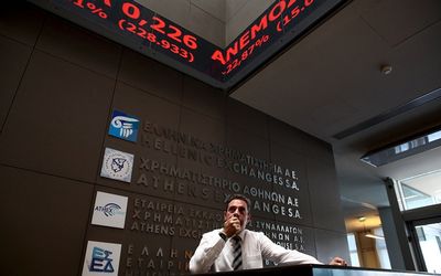 An employee looks on at electronic board displaying stock prices at the entrance of the Athens Stock Exchange Greece on Monday