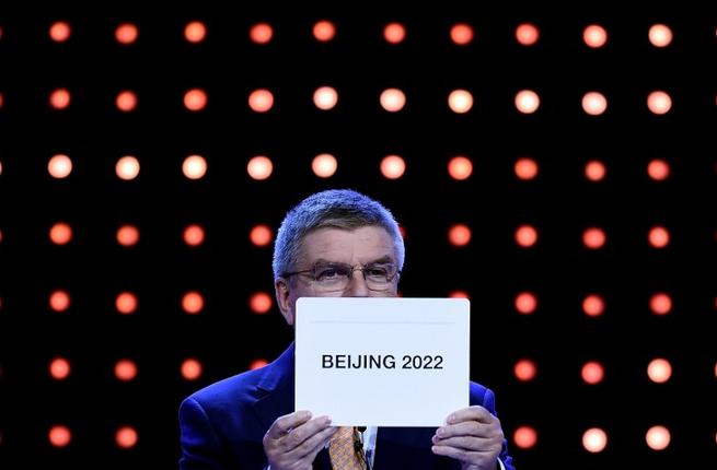 IOC president Thomas Bach shows the card with the name Beijing as the winning name of the 2022 Winter Olympic bid city