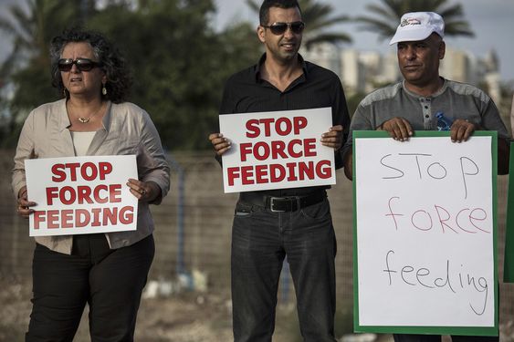 Israeli Arab supporters of Mohammed Allan a Palestinian prisoner on a hunger strike hold signs during a support rally outside Barzilai hospital in the costal city of Ashkelon Israel. Israel passed