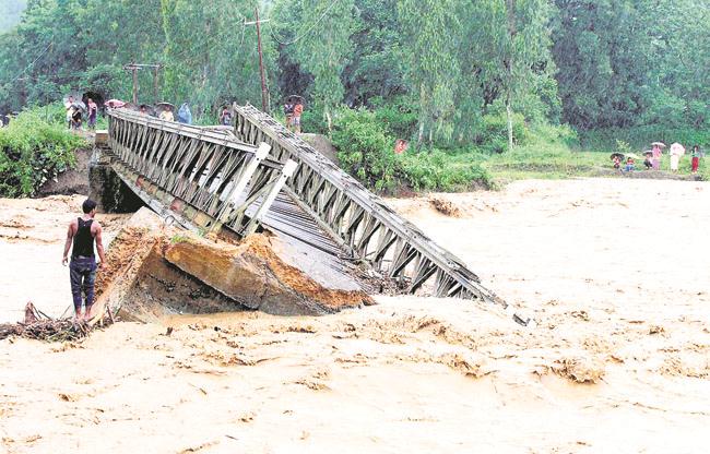 Landslides hit Manipur    
                       
        People look at the bridge which is washed away by the flood water in Thoubal District in Manipur