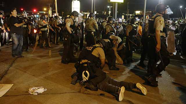 Police arrested nearly two dozen people in Ferguson during a fourth consecutive night of demonstrations marking the anniversary of the fatal shooting of 18-year-old Michael Brown