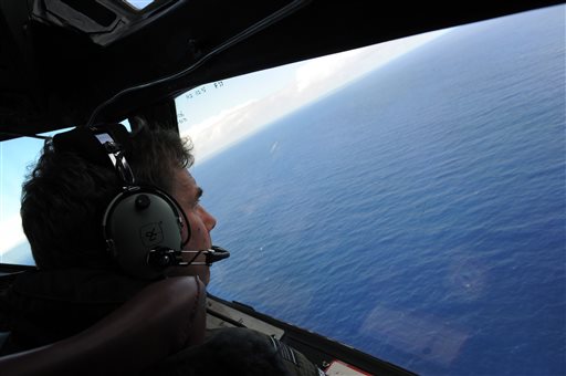 Royal New Zealand air force P-3K2-Orion aircraft co-pilot Squadron Leader Brett Mc Kenzie looks out of a window while searching for debris from missing Malaysia Airlines Flight 370 in the I