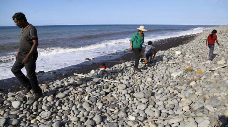 People walk on the beach where a large piece of plane debris was found on Wednesday in Saint-Andre on the French Indian Ocean island of La Reunion. Reuters