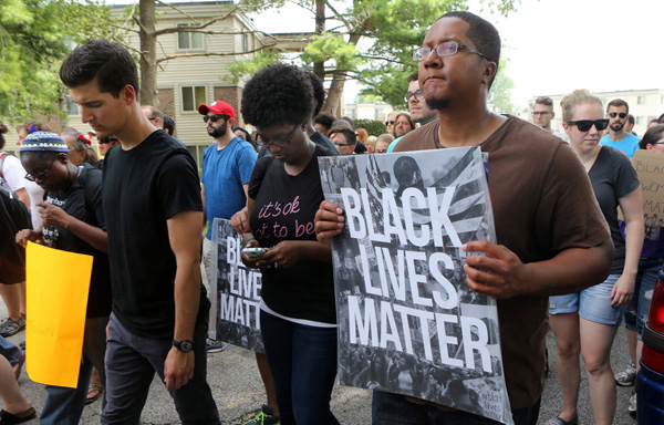 Marchers on Sunday start the walk to Greater St. Mark's Church from the spot where Michael Brown was killed a year ago in Ferguson Missouri