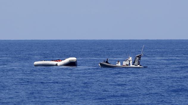 An Italian Navy boat from the ship Francesco Mimbelli approaches a rubber dinghy carrying migrants during a rescue operation off the coast of Libya. More than 200 migrants are feared to have drowned in the latest Mediterranean boat tragedy