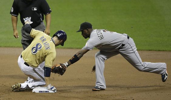 Braun slides in for a double ahead of the tag by Miami Marlins Adeiny Hechavarria during the first inning of a baseball game Tuesday Aug. 18 2015 in Milwaukee