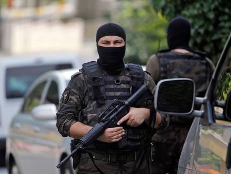 Masked Turkish police officers secure a road leading to the U.S. Consulate building in Istanbul Aug. 10