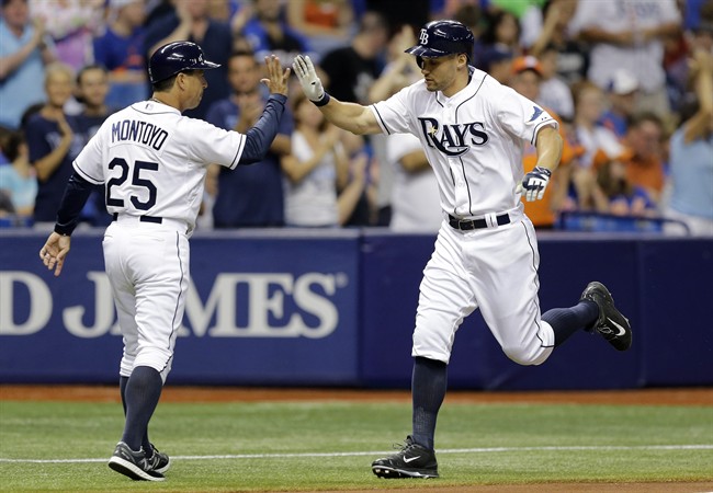 Tampa Bay Rays Grady Sizemore right high-fives third base coach Charlie Montoyo after hitting a home run off New York Mets starting pitcher Jacob de Grom during the fourth inning of an interleague baseball game Friday Aug. 7 2015 in St. Petersbu