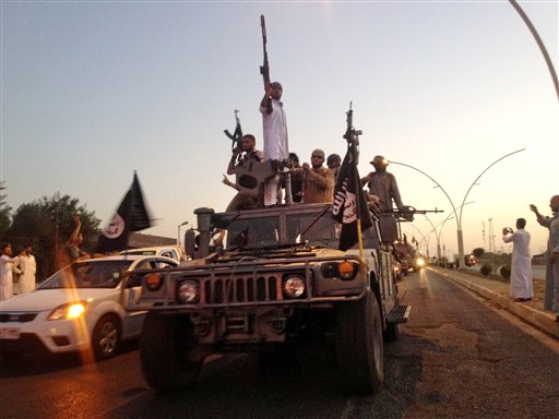 23 2014 fighters from the Islamic State group parade in a commandeered Iraqi security forces armored vehicle down a main road at the northern city of Mosul Iraq. An independent monitoring group says some bombings