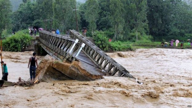 Flood-affected residents use a make-shift raft to travel through floodwaters in Kalay upper Myanmar's Sagaing region