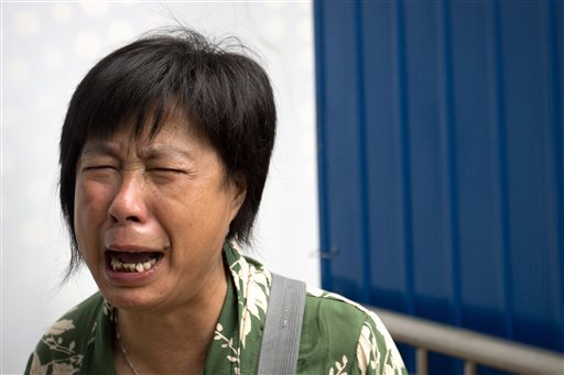 Bao Lanfang whose daughter-in-law son and granddaughter were aboard Malaysia Airlines Flight 370 cries as she protests outside the company's offices in Beijing Thursday Aug. 6 2015. About a dozen Chinese relatives of passengers protested outsi