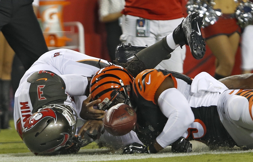 Tampa Bay quarterback Jameis Winston left loses the football as he is hit by Cincinnati’s Emmanuel Lamur after scoring on a 1-yard touchdown run in the first quarter Monday in Tampa Florida