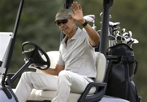 President Barack Obama waves to people from his golf cart while golfing Saturday Aug. 8 2015 at Farm Neck Golf Club in Oak Bluffs Mass. on the island of Martha's Vineyard. Obama is spending his first full day of vacation on the island playing