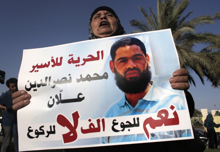 Maazouze the mother of Mohammed Allaan a Palestinian prisoner who is on a long-term hunger strike holds a portrait of her son during a rally calling for his release in the southern Israeli city of Beersheba