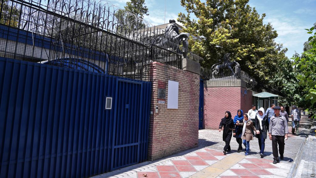 Pedestrians walk past the main gate of British Embassy in Tehran Iran