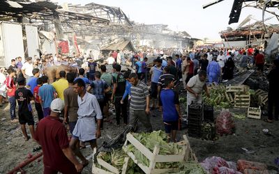 People gather at the site of a truck bomb attack at a crowded market in Baghdad Iraq on Thursday