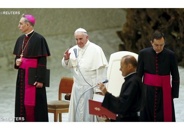 Pope Francis waves as he arrives to lead his Wednesday general audience in Paul VI hall at the Vatican