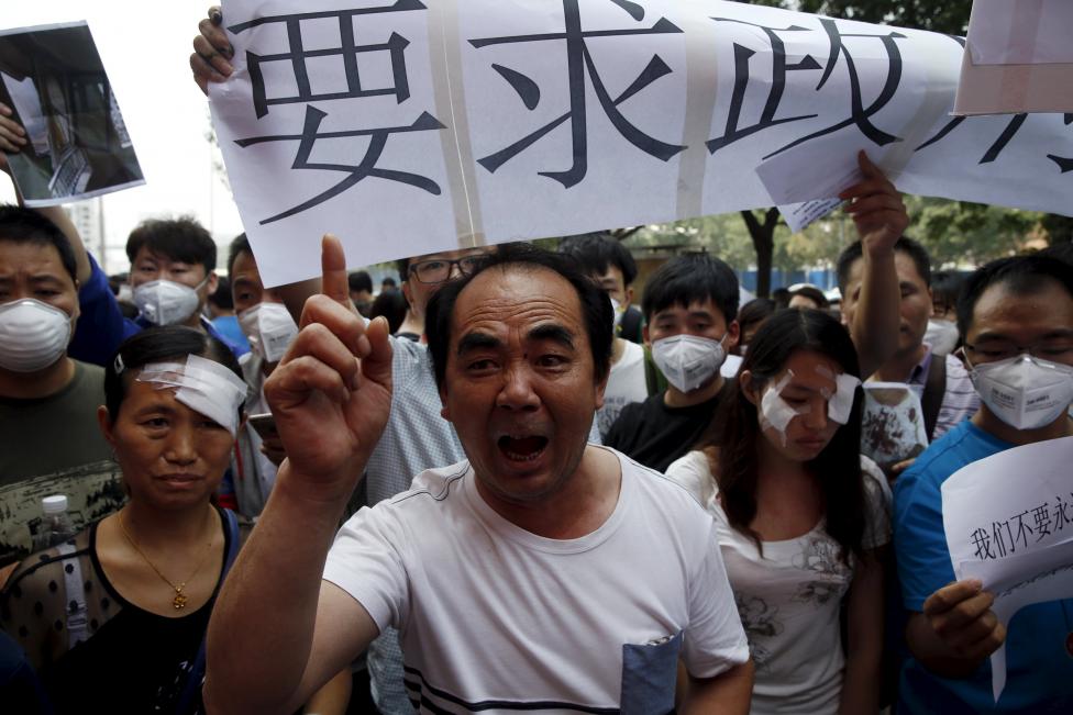 Residents evacuated from their homes after last week's explosions take part in a rally demanding compensation in Tianjin