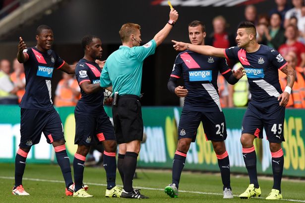 Aleksandar Mitrovic is shown a yellow card by referee Mike Jones