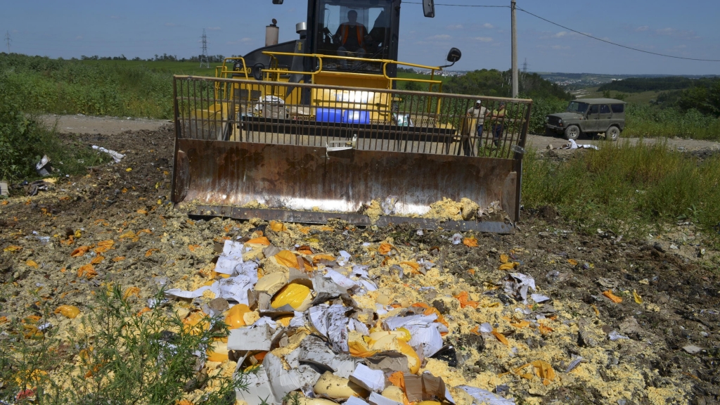 A bulldozer pushes illegal imported cheese in Russia on Thursday in