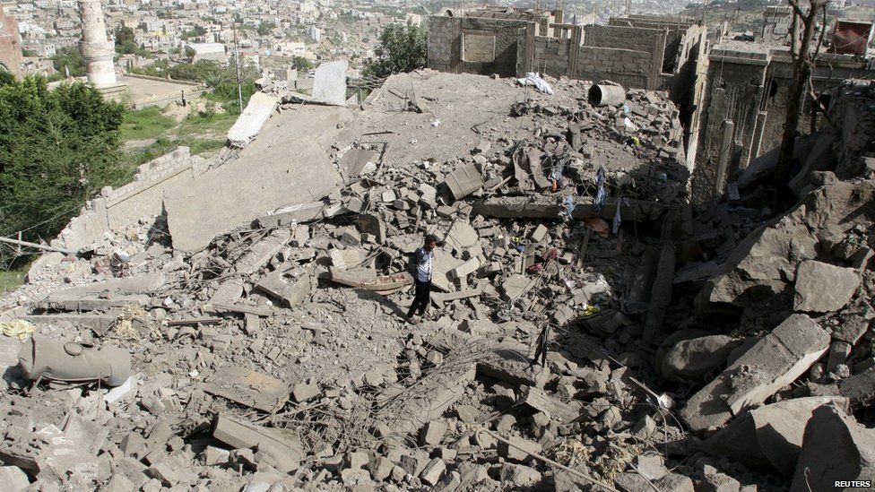 A man walks on the rubble of houses destroyed by Saudiled air strikes in Taiz on 21