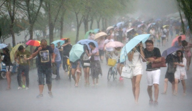 In this image released by the New Taipei Fire Department emergency rescue personnel carry a child through a flash mudslide caused by Typhoon Soudelor in Xindian New Taipei City northern Taiwan Saturday Aug. 8 2015. At least four people were killed