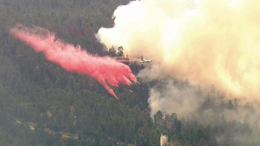 An air tanker drops fire retardant to quell flames that erupted from a brush fire near Snow Summit Ski Resort in Big Bear