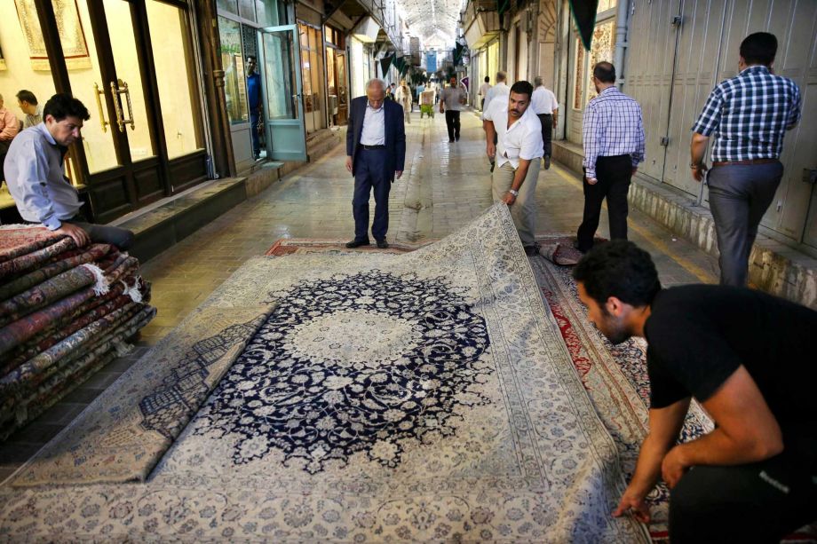 Iranian merchants display a carpet at Tehran's main bazaar Monday as weavers plan to re-enter U.S. market. at work following the country's historic nuclear deal with world powers anticipating a boost in exports as sanctions are set to be lifted in the