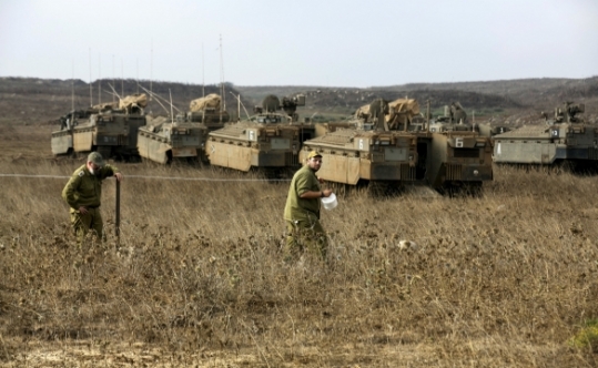 Israeli soldiers demarcate an area as they stand near armoured personnel carriers during an exercise in the Israeli Golan Heights near the ceasefire line between Israel and Syria