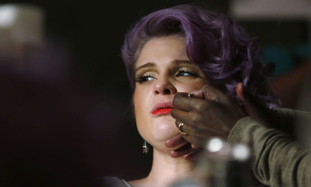 TV personality Kelly Osbourne has makeup applied before The Heart Truth's Red Dress Collection fashion show in New York