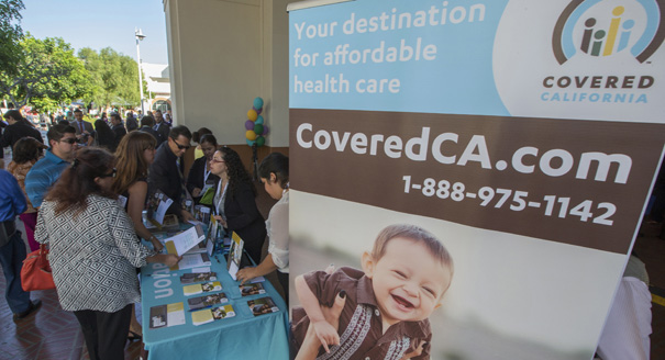 People sign up for health insurance information at a Covered California event in Los Angeles