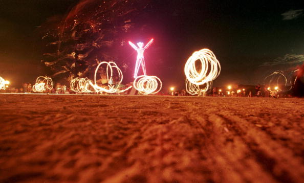 BLACK ROCK DESERT UNITED STATES Dancers at the'Burning Man festival create patterns with fireworks in the Black Rock Desert of Nevada just prior to burning a five-story neon-lit effigy of a man on the last night of the week-long festival 06 Septembe