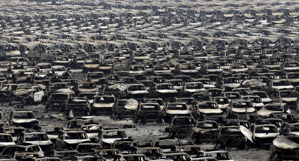 Damaged cars are seen near the site of the explosions at the Binhai new district Tianjin