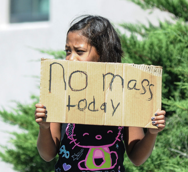 Aaliyah Doninguez 11 stands on N. Alameda Boulevard on Sunday Aug. 2 2015 in Las Cruces N.M. advising parishioners that Holy Cross Catholic Church mass is canceled. Churchgoers were left shaken during Sunday morning services after authorities say